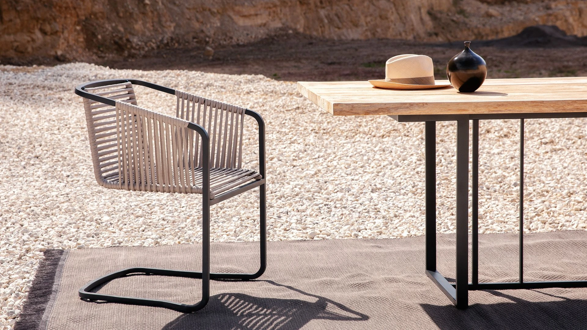 Suite Sessel und ein hoher Tisch an einer modernen Outdoor-Bar im Garten eines Wohnhauses.