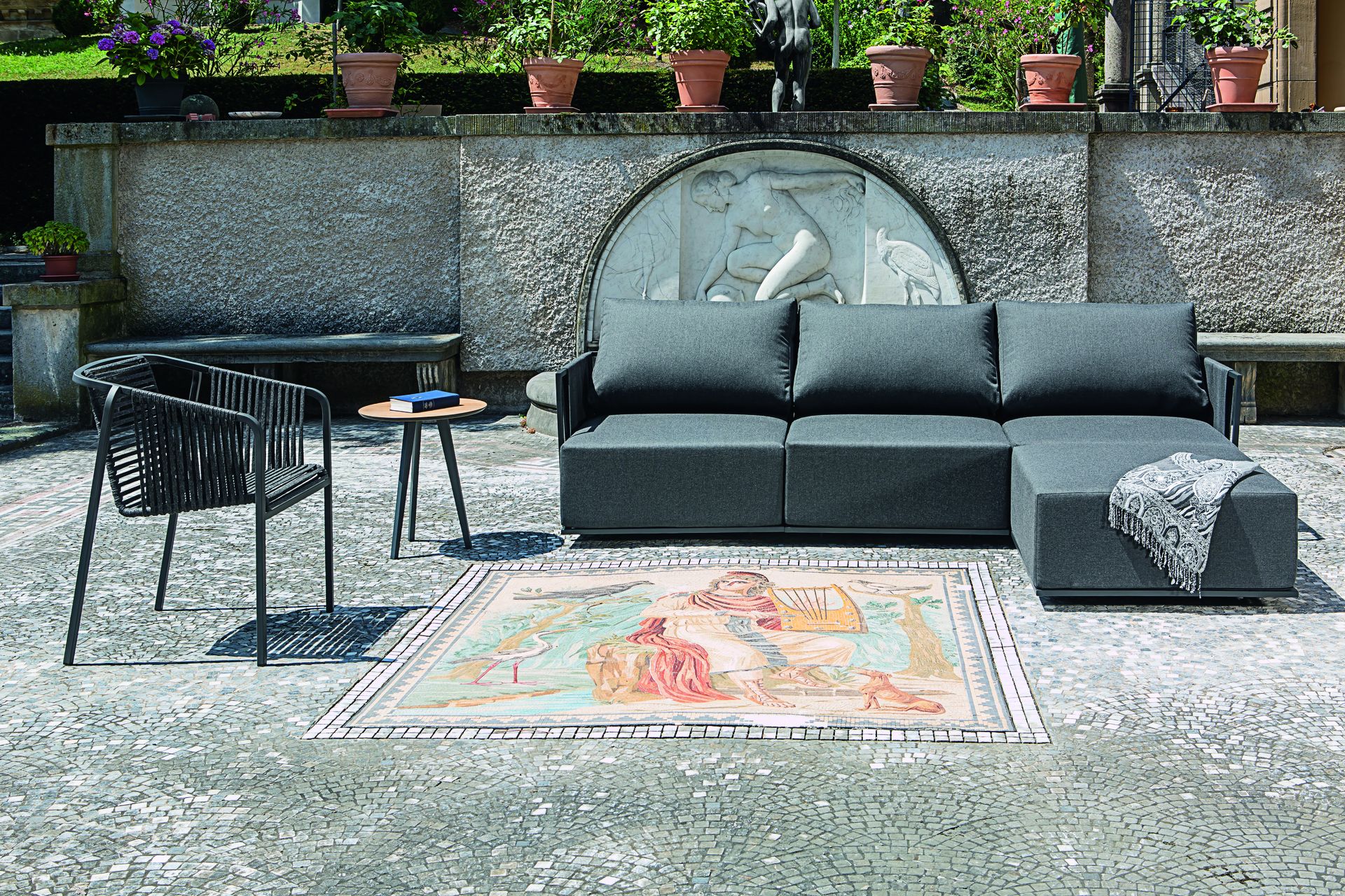 Suite High Dining-Gruppe mit hohem Bartisch und Barstühlen auf einer Holzterrasse vor moderner Architektur.